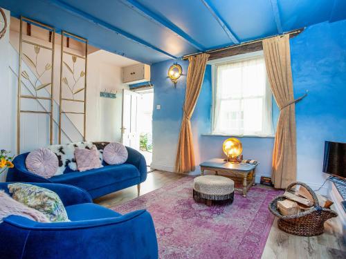 a living room with blue walls and a blue couch at Gypsett in Polruan
