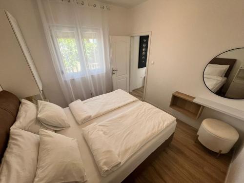 una piccola camera con letto bianco e specchio di Sea Dream Apartments a Bibinje (Bibigne)