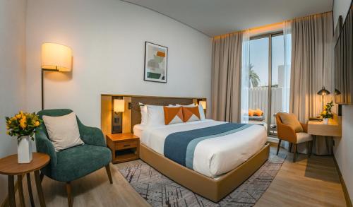 a hotel room with a bed and a chair at First Grand Hotel in Dammam