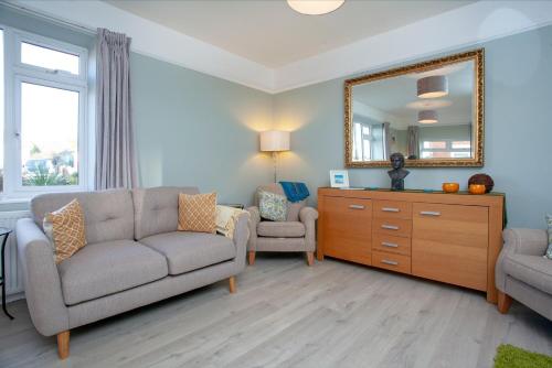 a living room with a couch and a mirror at Seymour House in Exmouth