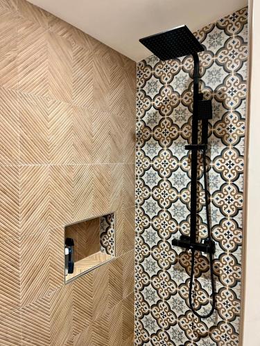 La salle de bains est pourvue d'un mur en carrelage et d'une cheminée. dans l'établissement Villa Christelle, à Soustons