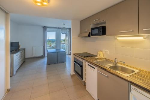 une cuisine avec un évier et un plan de travail dans l'établissement appartement 1ère ligne avec parking et terrasse vue mer, à Palavas-les-Flots