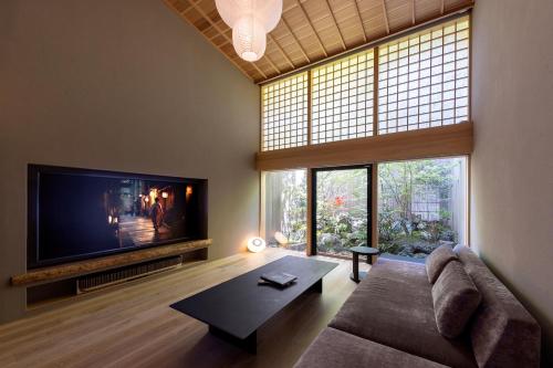 a living room with a couch and a large tv at Machiya Hideaway in Enchanting Geisha District in Kyoto