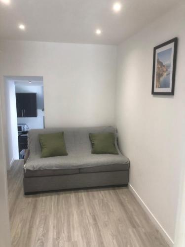 Cette chambre comprend un lit avec deux oreillers verts. dans l'établissement Villefranche, à Villefranche-sur-Mer