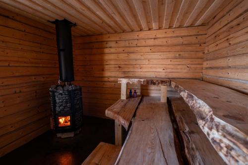a log cabin with a wood stove in it at Kutulammen erämökki saunalla in Ranua