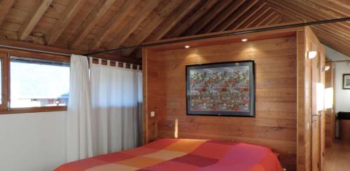 a bedroom with a bed in a room with wooden walls at La Bastide en Cévennes in Saint-Hilaire-de-Lavit