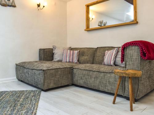 a living room with a couch and a mirror at Tarow Cottage in East Looe