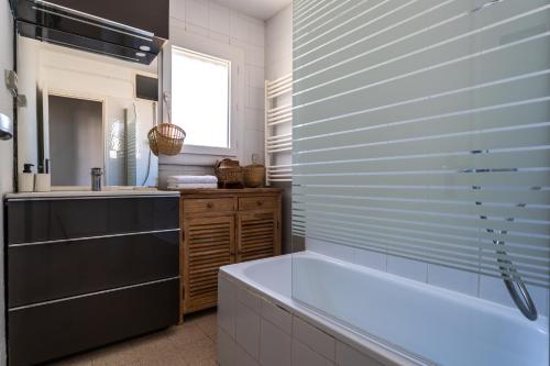 une salle de bain avec une baignoire et un lavabo dans l'établissement 1ère ligne avenue saint maurice avec vue mer, à Palavas-les-Flots