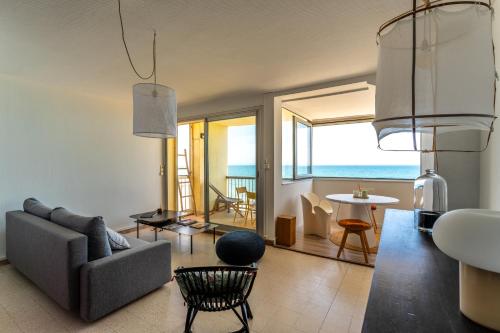 un salon avec un canapé et une table dans l'établissement 1ère ligne avenue saint maurice avec vue mer, à Palavas-les-Flots