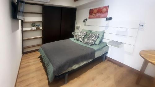 une chambre avec un lit avec des oreillers dessus dans l'établissement Place DANTON SERIGNAN CENTRE, à Sérignan