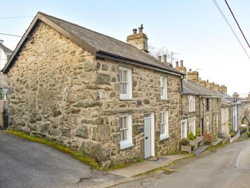 an old stone house on the side of a street at Tryfar House in Harlech