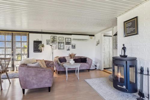 a living room with a couch and a fireplace at Astrup Vig Hideaway, Thatched Cottage with Shelter & Serenity in Roslev