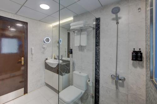 a bathroom with a toilet and a sink and a shower at Vendome Plaza Hotel in Dubai