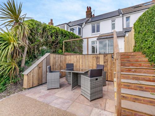 a patio with a table and chairs and a fence at Happy House in Bevendean