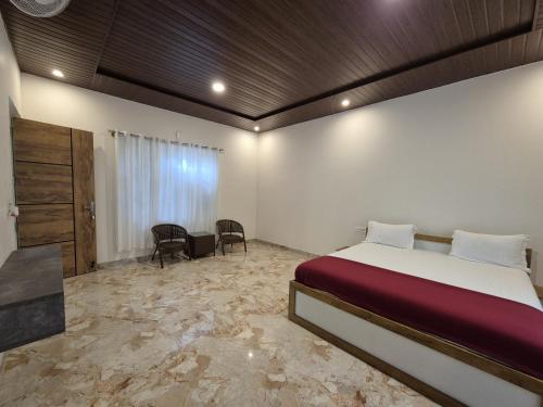 a bedroom with a bed and a table and chairs at Tropica Retreat by Dazzle Destinations - Private Waterfalls, Private Rooms and Bonfire in Aldūr