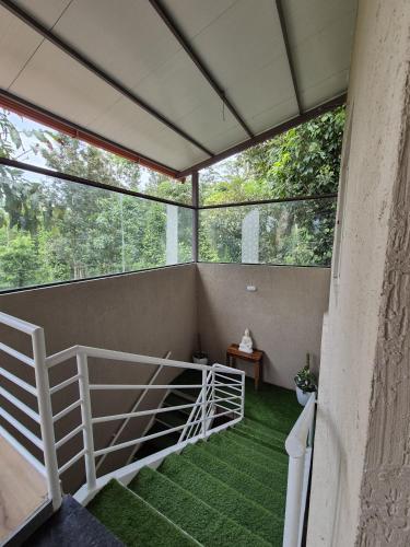 a screened in porch with a staircase and green grass at Tropica Retreat by Dazzle Destinations - Private Waterfalls, Private Rooms and Bonfire in Aldūr