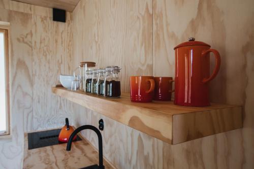 a kitchen counter with a red thermos on a shelf at Sukha Nordic Retreats in Arvika