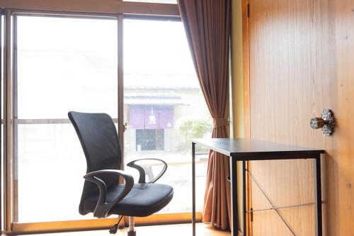 a chair and a desk in front of a window at 貸切御宿　憩（Ikoi）/ Nikko Kinugawa Area in Imaichi