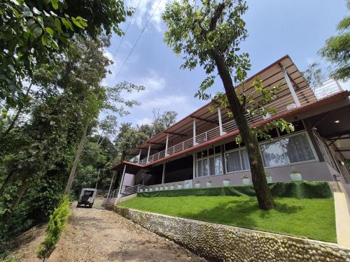 a house with a tree in front of it at Tropica Retreat by Dazzle Destinations - Private Waterfalls, Private Rooms and Bonfire in Aldūr