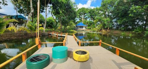 a boat with three buckets on the side of a river at An Nhien Garden in Long Khanh