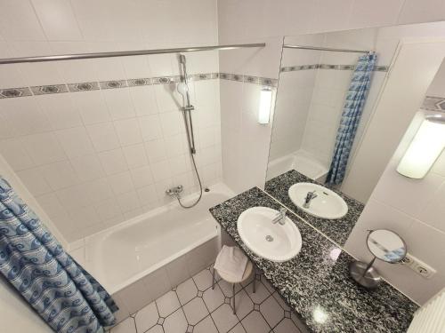a bathroom with a sink and a shower and a tub at Ferienwohnung Sonnenwiese in Wittenbeck