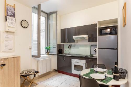 une cuisine avec une table et un réfrigérateur dans l'établissement large studio near train station, very central, à Nîmes