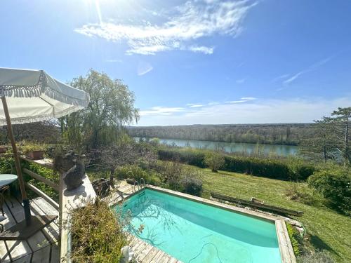 une piscine dans une cour avec vue sur une rivière dans l'établissement Dôme en bois avec Piscine et sa Vue seine et forêt, à Fontaine-le-Port