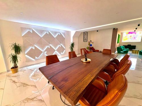 une salle à manger avec une table et des chaises en bois dans l'établissement Loft 250 m2 Toit Terrasse Parking Netflix, à Douai