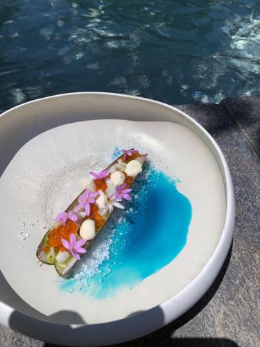 a piece of food on a plate next to the water at Noccemada "Spirit of Bali" Lodge, Pool & Spa in Saint-Julien