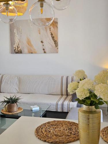 a living room with a couch and a table with flowers at The studio and The view in Vlachata