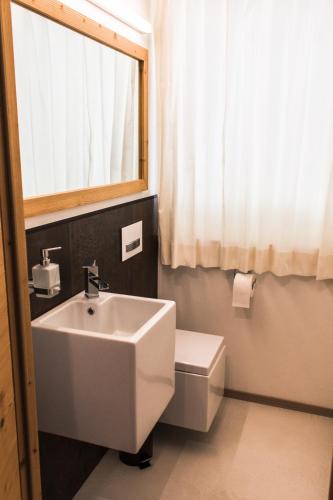 a bathroom with a sink and a toilet and a window at Moar Lodge in Postal