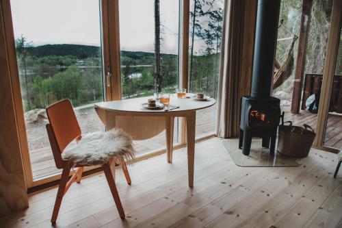 a table and chair in a room with a stove at Sukha Nordic Retreats in Arvika