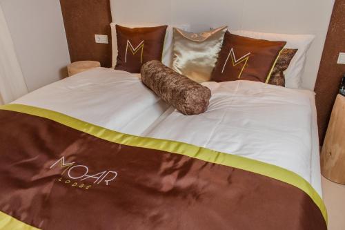 a bed with a comforter and pillows on it at Moar Lodge in Postal