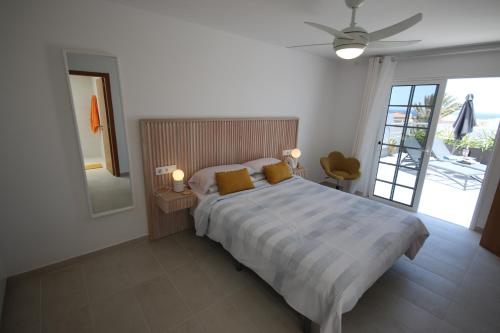 una camera da letto con un letto grande e una grande finestra di LAS ROSAS by RENTMEDANO Stunning luxury Chocolate Box villa with private heated pool & wifi a El Médano