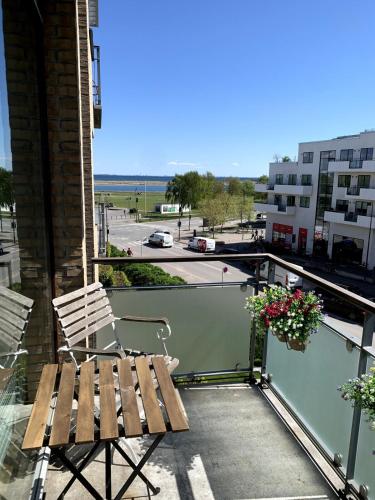 a chair on a balcony with a view of a street at On the beach, close to city centre & airport in Copenhagen