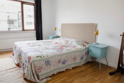 a bedroom with a bed and a blue nightstand and a window at On the beach, close to city centre & airport in Copenhagen