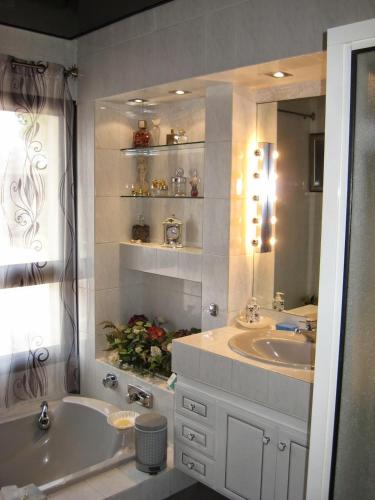 une salle de bain avec deux lavabos, une baignoire et un miroir dans l'établissement Villa Tout Standing Lege Cap-Ferret, à Lège-Cap-Ferret