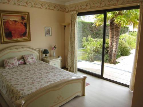 une chambre avec un lit et une porte coulissante en verre dans l'établissement Villa Tout Standing Lege Cap-Ferret, à Lège-Cap-Ferret