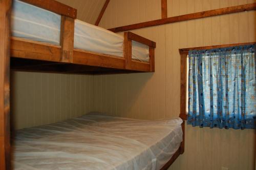 una camera con 2 letti a castello e una finestra di O'Connell's RV Campground Lakefront Cabin 9 a Inlet