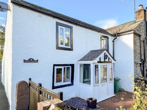 a white house with a white door and windows at Smithy Cottage in Keldhead