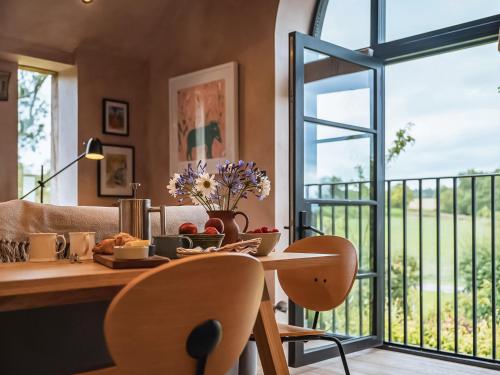 una sala da pranzo con un tavolo e una grande finestra di Olive a Kelsall