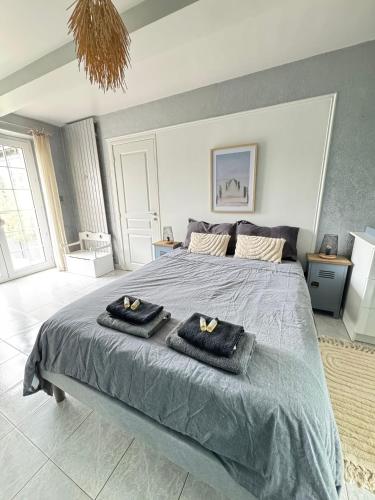 une chambre avec un lit avec deux serviettes dessus dans l'établissement Chambre double dans villa avec piscine salle de bains privée, à Roézé-sur-Sarthe