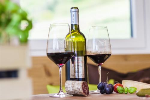 two glasses of red wine sitting on a table at Moar Lodge in Postal