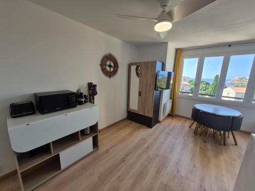 - un salon avec un réfrigérateur et une table dans l'établissement City center apartment with sea view, à LʼÎle-Rousse