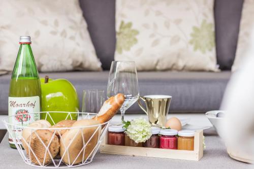 a table with a basket of food and a bottle of wine at Moar Lodge in Postal