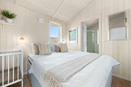 a bedroom with a large white bed with a window at Ferienhaus Harzliebe - Sankt Andreasberg im Harz in Sankt Andreasberg