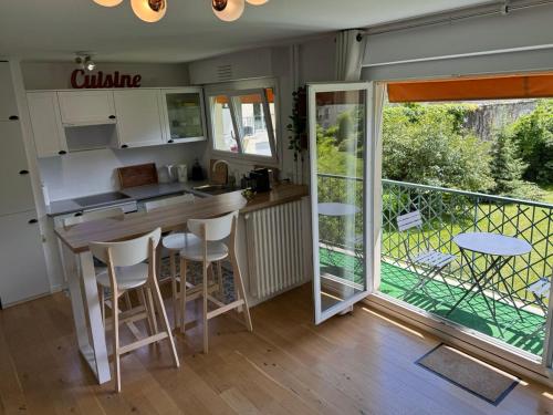 Il dispose d'un balcon et d'une cuisine avec une table et des chaises. dans l'établissement Superbe appartement avec belle vue jardin, à Paris