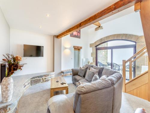 a living room with a couch and a tv at Baxter Barn in Carleton