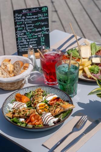 une table avec deux assiettes de nourriture dans l'établissement Camping Le Suroit, au Bois-Plage-en-Ré