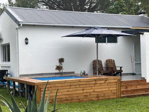a patio with an umbrella and a swimming pool at Welbedacht Game & Nature Reserve in Tulbagh